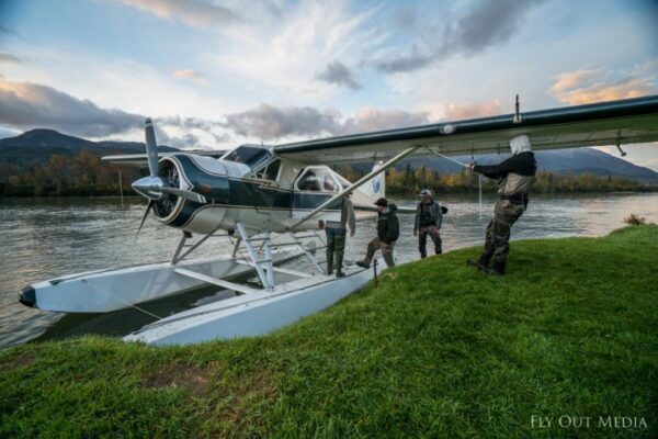 Anglers boarding a floatplane at the river's edge